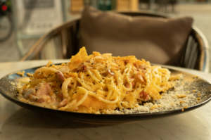 a plate of spaghetti topped with meat and cheese