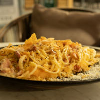 a plate of spaghetti topped with meat and cheese